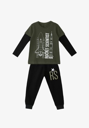 T-shirt vert olive avec un design de fusée et le texte "ROCKET SCIENTIST", associé à un jogging noir portant une broderie "RS" et des étoiles.