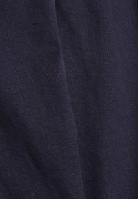 Marinblått tyg med en jämn struktur, som har subtila nyansvariationer. Materialet ser lättviktigt ut och är något skrynkligt.