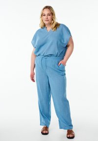 Blå linne tvådelad outfit med en lös V-ringad topp och avslappnade byxor med elastisk midja och sidofickor.