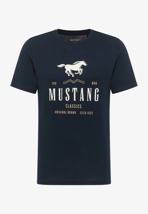 Tamsiai mėlyna trumpomis rankovėmis marškinėliai, pagaminti iš medvilnės. Sukurtas su balta arklio grafika ir smėlio spalvos tekstu: "MUSTANG CLASSICS" ir "ESTD 1932".