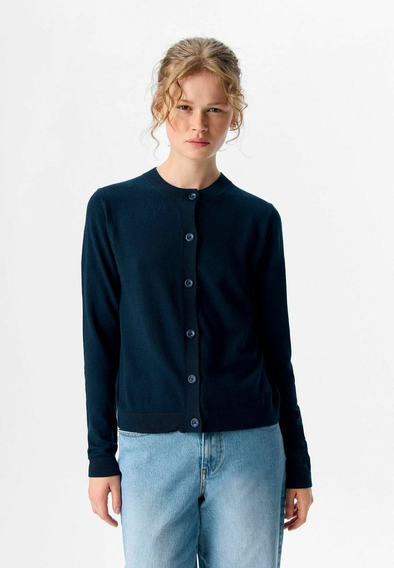 Marineblauer Cardigan aus weichem Stoff, mit rundem Halsausschnitt, langen Ärmeln und einer Knopfleiste auf der Vorderseite, sowie gerippten Bündchen und Saum.