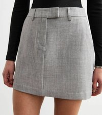 Grå strukturerad minikjol med en slät yta. Har en platt midja, sidfickor och en skräddad design för en elegant look.