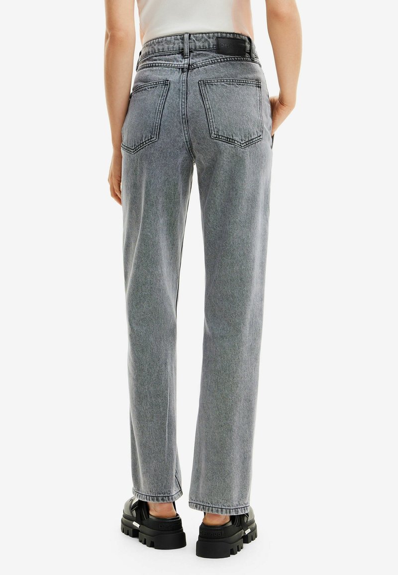 Jeans de tiro alto y pierna recta en denim gris claro. Con bolsillos de parche, costuras visibles y una textura ligeramente deslavada.