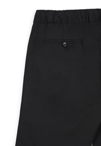 Pantaloni neri con vita elastica e una sola tasca posteriore fissata da un bottone, mostrati dalla vita posteriore fino a metà coscia.