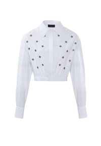 Camicetta bianca cropped con maniche lunghe, caratterizzata da ricami a stella nera sulla parte frontale. Vita elasticizzata e design con colletto classico.