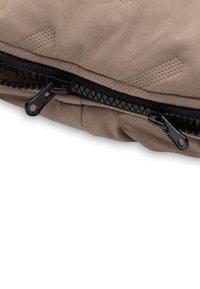 Beige ritszakje gemaakt van zachte stof, met een textuurontwerp en zwarte ritsdetails voor een veilige sluiting.