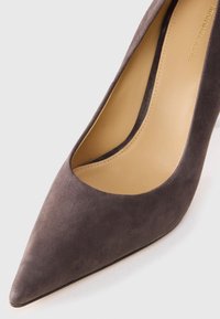 TACCO ALTO GRIGIO IN CAMOSCIO CON PUNTA RICURVA E INTERNO LISCIO. LA SCARPA PRESENTA UNA LEGGERA CURVATURA ALL'APERTURA PER UN MAGGIORE COMFORT.