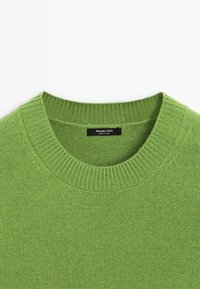 Pull vert en maille à col rond avec col côtelé et une étiquette noire indiquant « Massimo Dutti Made in China » à l'intérieur de l'encolure.