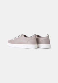 Heledad hallid sneaker'id, mis on valmistatud siledast nahast, valgete paeltega ja kummitaldadega, millel on tekstureeritud muster haardumise saavutamiseks. Minimalistlik disain.