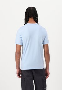 Ανοιχτό μπλε βαμβακερό t-shirt με κοντά μανίκια και στρογγυλή λαιμόκοψη, απλός σχεδιασμός, λεία υφή και ελαφρώς στενή γραμμή.