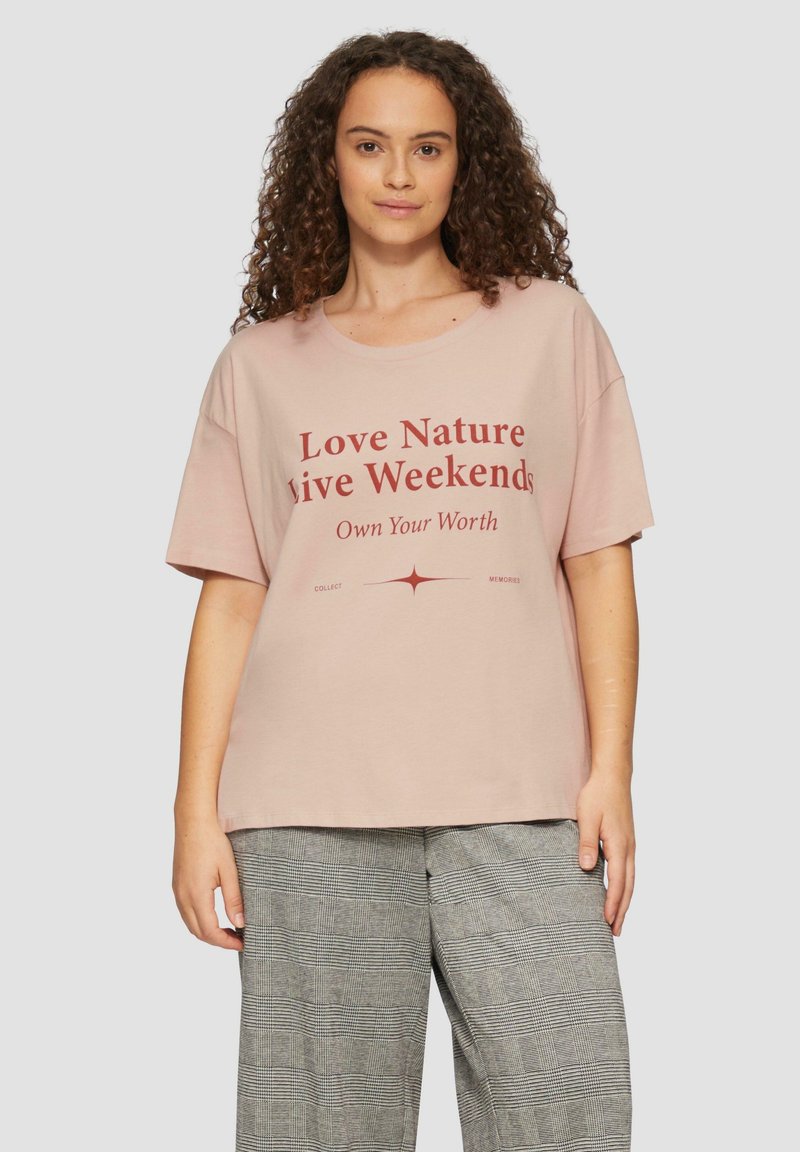 Lichtroze katoenen t-shirt met korte mouwen, voorzien van een gedurfde rode grafische tekstontwerp. Casual pasvorm en ronde halslijn.