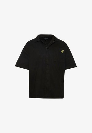 Zwarte kortemouwen shirt van katoen met een zak aan de voorkant. Bevat een geel slangenlogo op de borst en een knoopsluiting aan de voorkant.