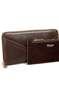 Brown leather wallet with a zip closure, embossed logo, and a secondary cardholder made of dark brown suede. Textured accents visible.