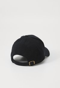 Zwarte corduroy pet met een ronde kroon en een gebogen klep. Voorzien van een metalen gesp aan de achterkant en ventilatie-oogjes.