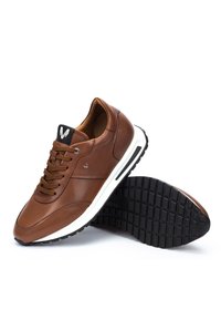 Brown leather sneaker with white midsole and black tread sole, featuring brown laces and a black tongue label with a white logo.