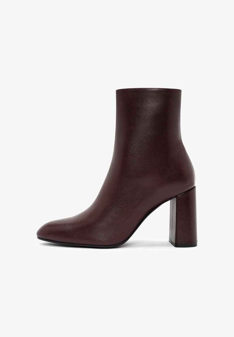 Stivaletto borgogna con finitura in pelle liscia, punta affusolata e tacco trasparente chunky. Design elegante e minimalista.