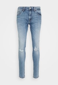 Jeans pitillo de mezclilla azul claro con cintura alta, con desgarrones en las rodillas y el clásico diseño de cinco bolsillos. Textura lisa, sin adornos.