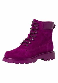 Fialové semišové kotníkové boty s tlustou gumovou podrážkou, zaoblenou špičkou a kontrastními černými tkaničkami. Mají polstrovaný límec a detaily bočního švu.