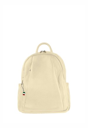 Cream-colored leather backpack with top handle, front zipper pocket, side pockets, and small Italian flag keychain on zipper pull.