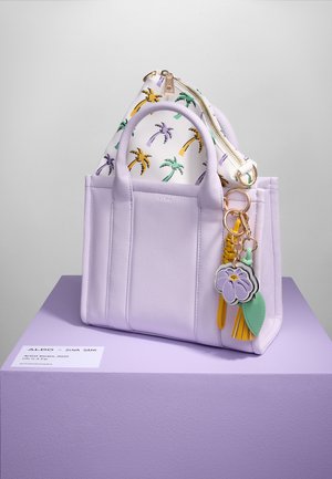 Lavender faux leather tote bag with dual handles, featuring a white inner pouch with palm leaf pattern and colorful decorative charms.