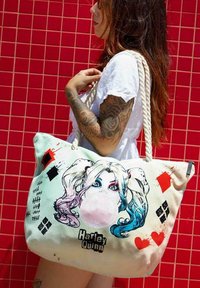 Bolso tote de Harley Quinn con diseño impreso, material de algodón, tamaño grande, colores pastel y elementos decorativos como corazones y gráficos.