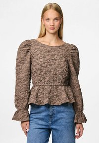 Blusa marrone a tinta unita con vita a peplum, maniche a sbuffo e polsini svasati, caratterizzata da un motivo di tessuto stropicciato e scollatura rotonda.