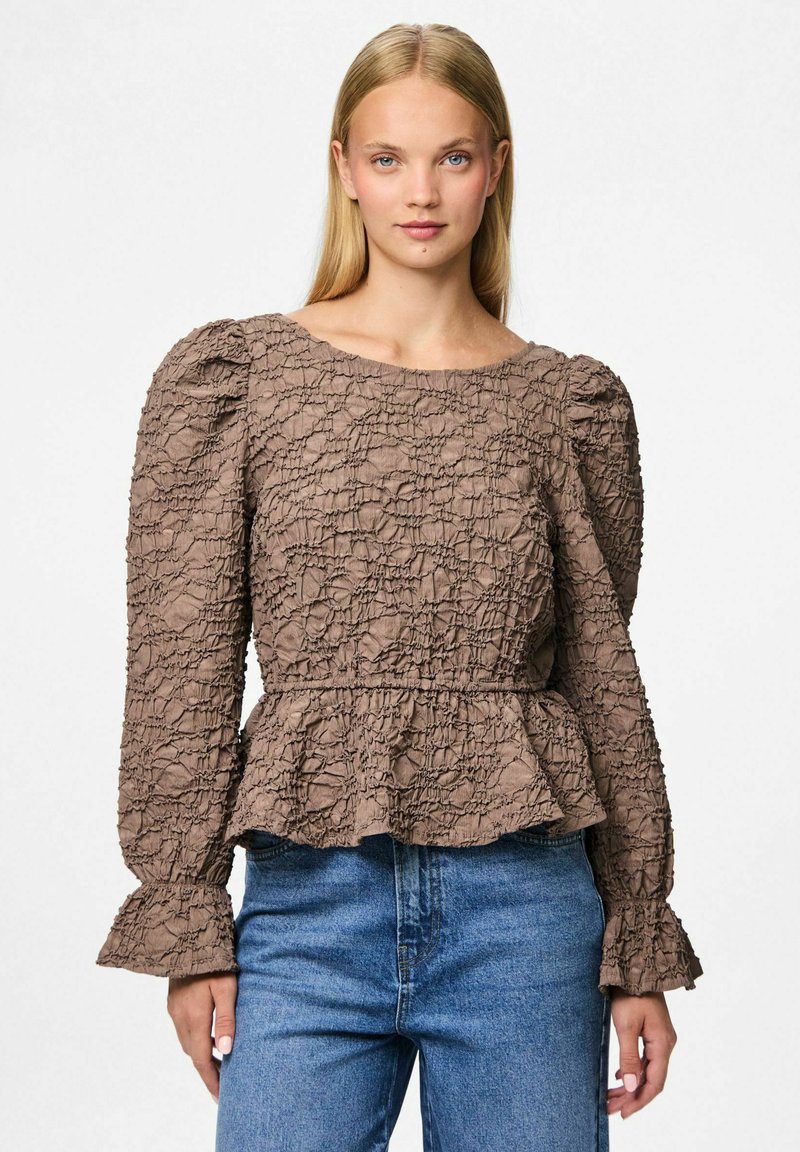 Blusa marrone a tinta unita con vita a peplum, maniche a sbuffo e polsini svasati, caratterizzata da un motivo di tessuto stropicciato e scollatura rotonda.