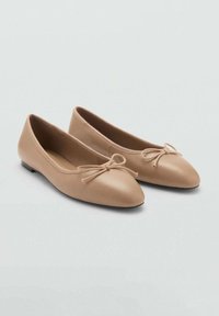 Ballet flats in nude leer met een ronde neus, platte zool en een decoratieve strik aan de voorkant. Glad textuur, minimalistisch ontwerp.
