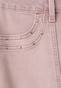 Tissu en denim rose clair avec bord de poche cousu, rivets argentés et passants de ceinture.