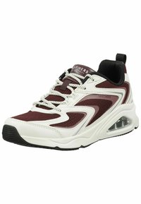 Zapatillas rojas y blancas con parte superior de malla, suela gruesa con una bolsa de aire visible, acentos en contraste y cordones redondos. Detalle de forro negro.
