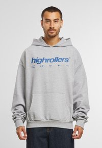 Világosszürke kapucnis felső, elöl egy nagy kék "highrollers" logóval. Előoldali zsebe, húzózsinóros kapucnija és bordás mandzsettái vannak.