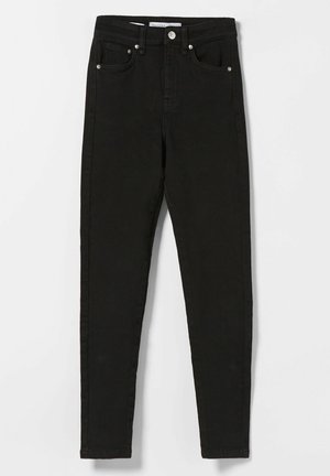 Jean skinny noir taille haute avec boutons à l'avant et design cinq poches, posé à plat sur fond blanc.