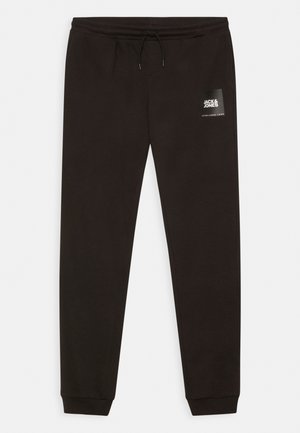 Czarne spodnie dresowe z elastycznym pasem i sznurkiem, ściągaczami przy nogawkach oraz naszywką z logo "Jack & Jones" na lewej udzie.