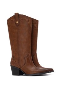 Botas de vaquero de cuero marrón con punta afilada, tacón apilado, costuras decorativas y cortes a lo largo del eje.