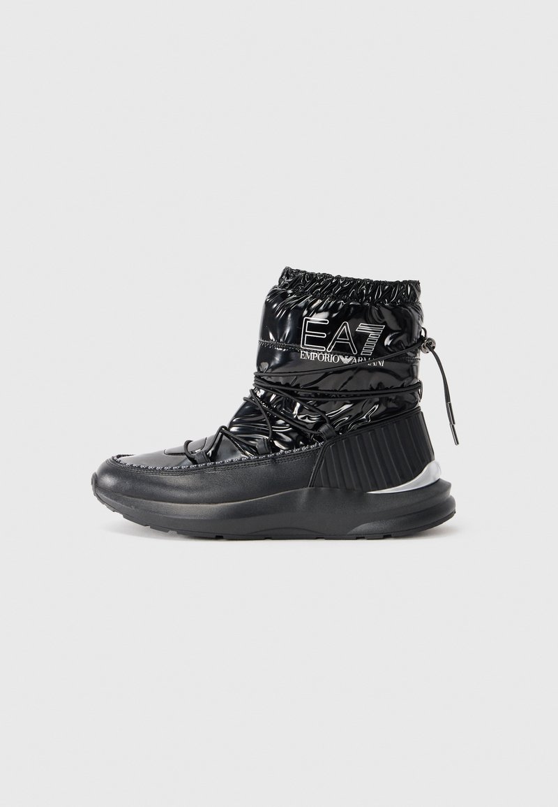 Black padded ankle boots with a glossy finish, elasticized top, and contrasting textured panel. Features laces and branding on the side.