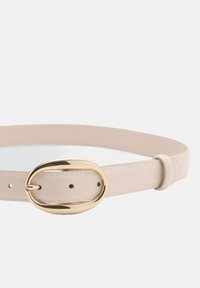 Smalle beige leren riem met een ovale gouden gesp, voorzien van verstelbare gaatjes langs de band en een gladde textuur.