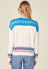Cremefarbenes Sweatshirt mit blauen, türkisfarbenen und burgunderfarbenen Rautenmuster. Mit geripptem Kragen und Bündchen abgeschlossen, entworfen für eine lässige Passform.