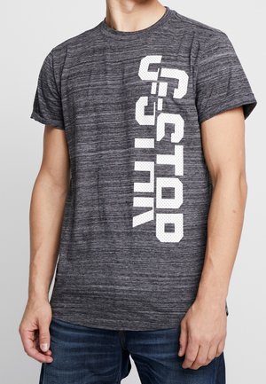 Szara koszulka z krótkim rękawem z białym wzorem graficznym z przodu, wykonana z teksturowanej, oddychającej tkaniny. Luźny krój i okrągły dekolt.