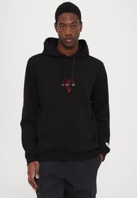 Hoodie noir en mélange de coton, avec une poche avant et des cordons de serrage. Cœur rouge brodé et texte sur la poitrine. Texture lisse.