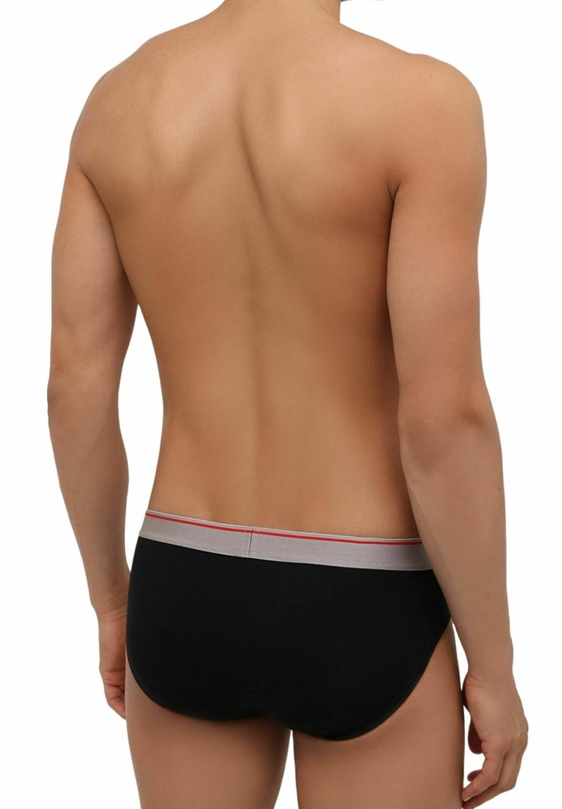 Czarne slipki z wąskim szarym pasem w kolorze czerwonym, dopasowany krój i gładki materiał. Widok z tyłu.