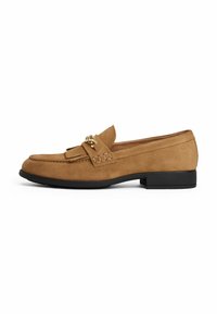 Tan suede loafer with a front tassel detail and gold hardware accents. Features a rounded toe and a low black sole.