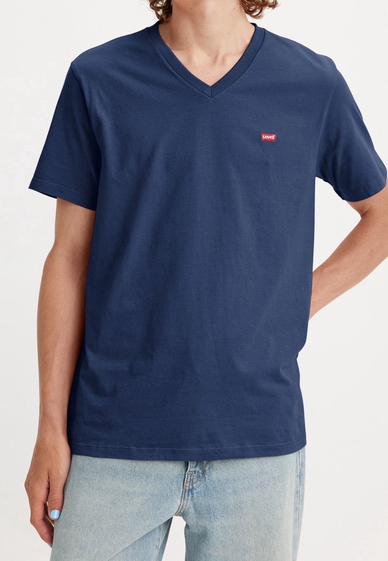 Mørkeblå bomulds T-shirt med v-hals, korte ærmer og et lille rødt Levi's-logo på brystet. Blød tekstur, normal pasform.