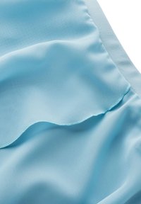 Himmelblaues Gewebe mit einer glatten, weichen Textur und einem dezenten Glanz. Enthält ein gewelltes Saumdetail und tonale Nähte.