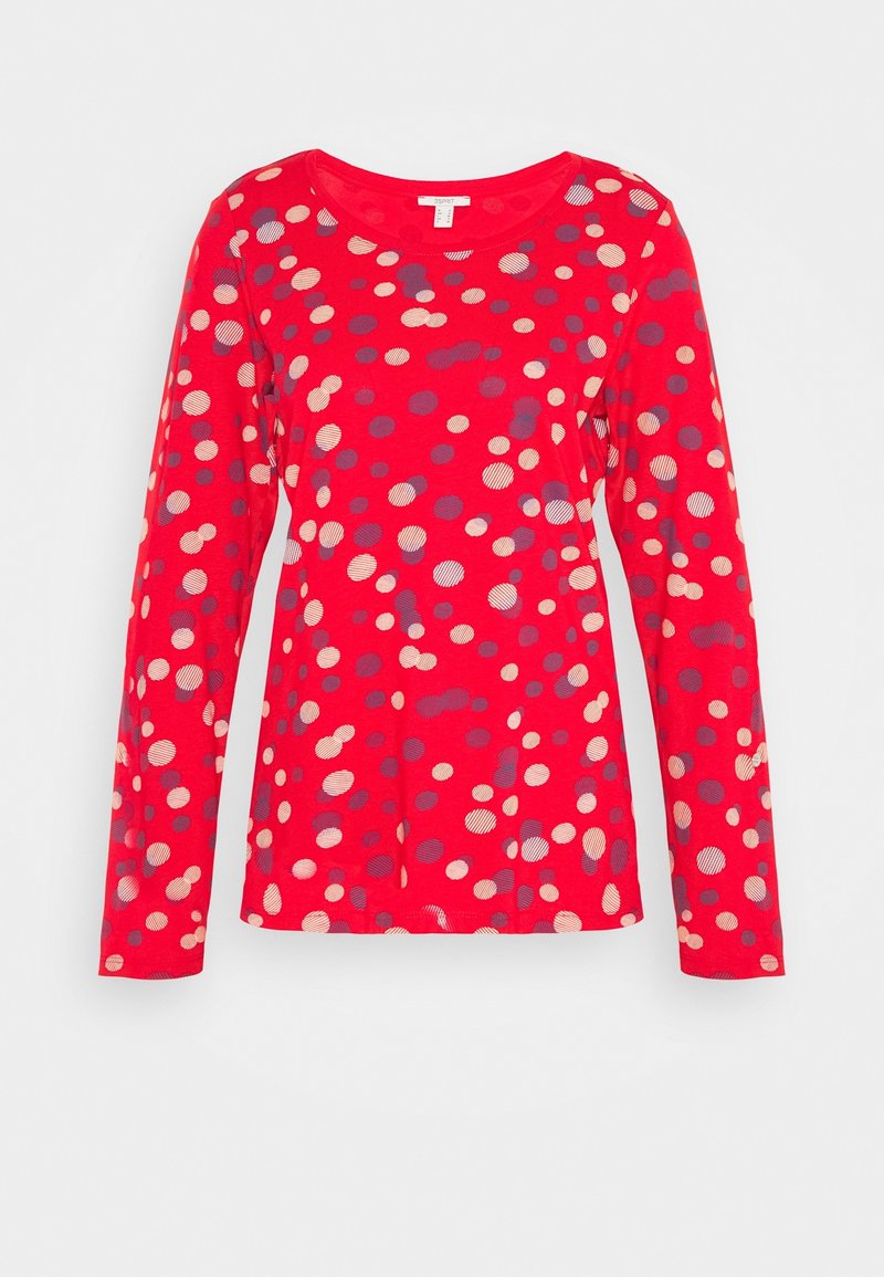 Red long-sleeve t-shirt featuring a pattern of varied-sized polka dots in cream and blue tones, rounded neckline, and soft texture.