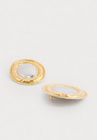 Cercei aurii cu un cadru exterior rotund, texturat și un centru circular neted și reflectant, având închidere cu tijă.