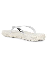 White flip-flop with textured woven sole, featuring sleek cross straps and a metallic accent. Lightweight design suitable for casual wear.