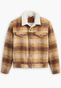 Chaqueta a cuadros en tono marrón y beige, con un suave cuello blanco, dos bolsillos en el pecho y botones de presión plateados. Diseño de tela con textura suave.
