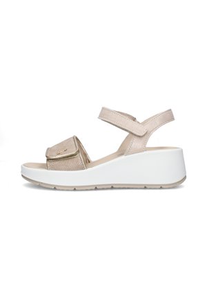 Sandalo beige con zeppa aperta sulle dita, cinturini regolabili alla caviglia e sulla parte anteriore, tomaia texturizzata e suola bianca spessa.