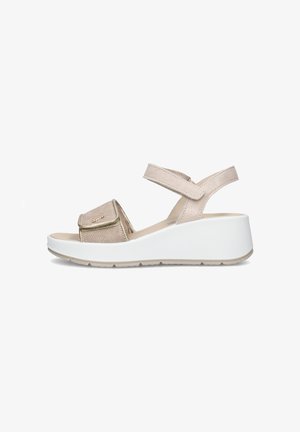 Sandalo beige con zeppa aperta sulle dita, cinturini regolabili alla caviglia e sulla parte anteriore, tomaia texturizzata e suola bianca spessa.