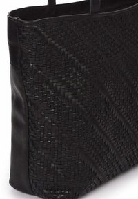 Bolso tote de cuero trenzado negro con textura diagonal. Los lados de cuero suave complementan los intrincados detalles trenzados, creando un diseño estructurado.